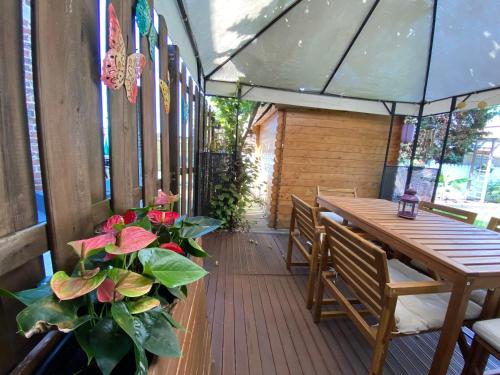 a patio with a wooden table and chairs and flowers at Maison lumineuse à 15 min de Bruxelles in Zaventem