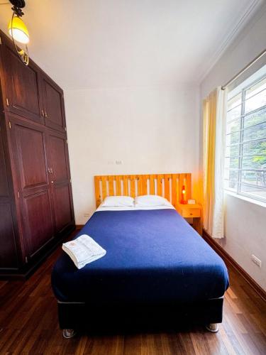 a bedroom with a bed with a blue blanket at Casaroma Hostels in Lima