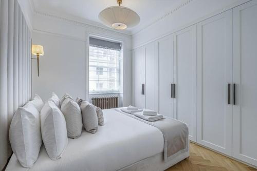 a white bedroom with a large white bed with pillows at Super Lux 3 Bed Apartment by Mayfair in London