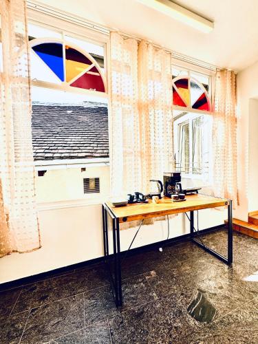 a table in a room with two windows withbows at Spacious 5BR shared Apartment Near Kaufpark Alterlaa in Vienna