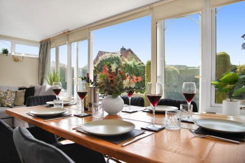 a table with wine glasses and a vase with flowers at WhiskAwayStays Toulouse Drive in Norton Junction