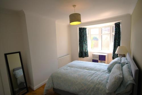 a bedroom with a bed and a window at 3 Bed Family House and Garden in Hanworth