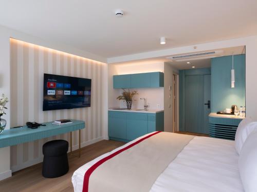 a bedroom with a bed and a desk and a kitchen at Taksim Juno Residences in Istanbul