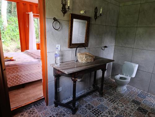 a bathroom with a table with a toilet and a mirror at Made in Roça in Piedade