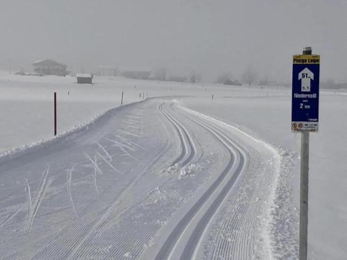 a snow covered road with a sign in the middle at Chalet in Niedernsill near Ski Slopes in Niedernsill