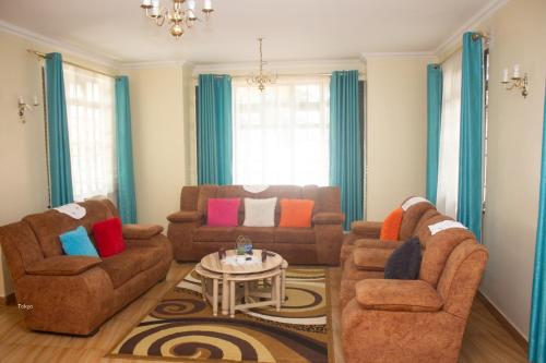 a living room with two couches and a table at Amigo apartments in Kisumu