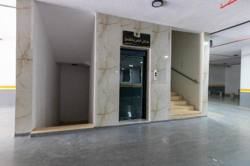 a lobby with a marble wall with a glass door at فندق لوكسري سويتس- Luxury Suites Hotel in Taif