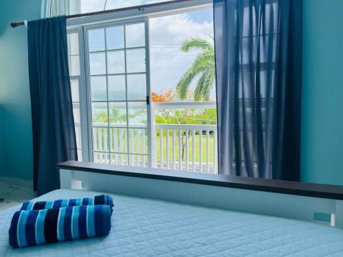 a bedroom with a window and a bed with a pillow at Luxury Guesthouse And Rooms The Lagoons in Montego Bay