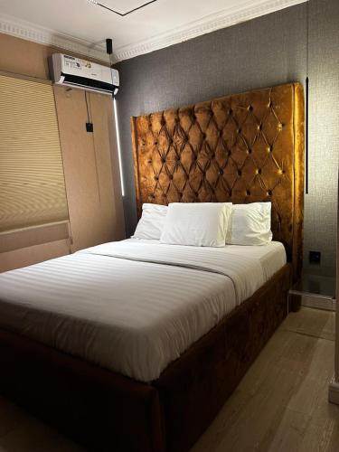 a bedroom with a large bed with a padded headboard at Molo Apartments in Lekki