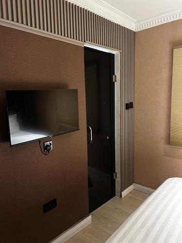 a bedroom with a door with a television on the wall at Molo Apartments in Lekki