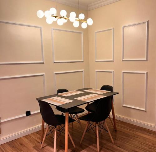 a dining room with a black table and chairs at Molo Apartments in Lekki