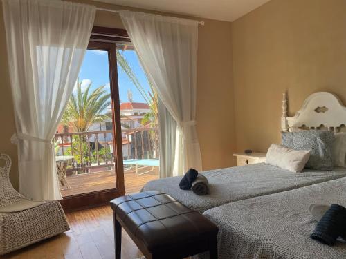 - une chambre avec 2 lits et une porte coulissante en verre dans l'établissement Parque Holandés Fuerteventura casa Mayte, à La Oliva