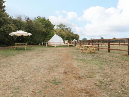 a group of picnic tables and a white tent at Bell 3 in Cirencester