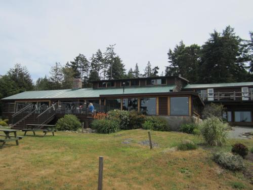 a large house with people standing on the deck at The Surf Lodge and Pub in Gabriola
