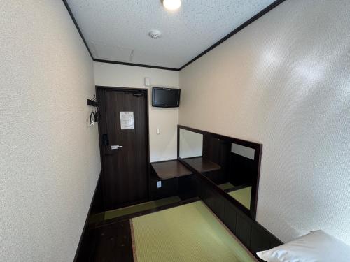 a small room with a staircase and a door and a television at Tsuyukusa in Takayama