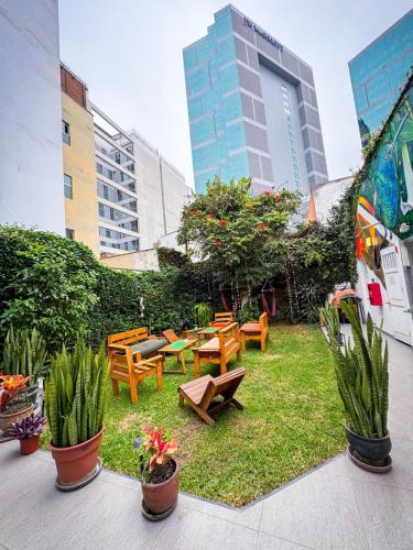 a garden with benches and tables in a city at Casaroma Hostels in Lima