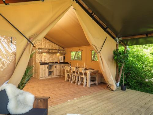 a tent with a table and chairs on a deck at Slow Living bij Mölke X Glamping in Zuna