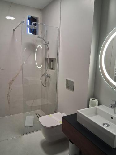 a bathroom with a shower and a toilet and a sink at Monterai Resort in Poiana Brasov