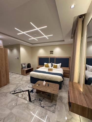 a hotel room with a bed and a table at Dani Serviced Apartments in Buqayq