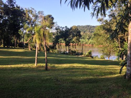 a park with trees and a river in the background at La Mision Mocona - Lodge de Selva in Saltos del Moconá