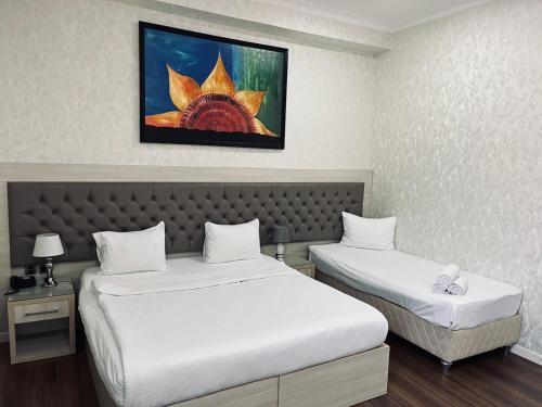 a hotel room with two beds and a painting on the wall at Empire Boutique Hotel Baku in Baku