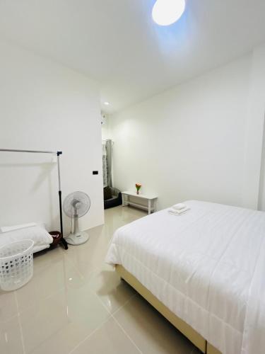 a white bedroom with a white bed and a white floor at Hatyai city habibi home 1 in Sathani Hat Yai