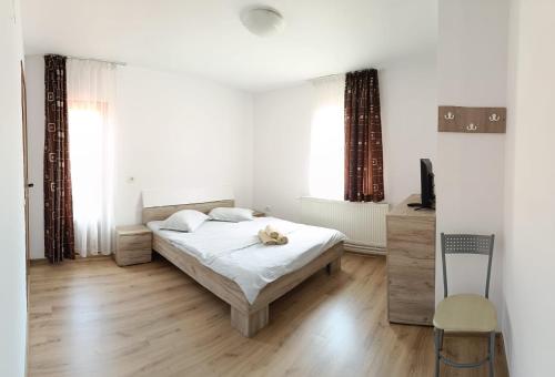 a bedroom with a bed with a teddy bear on it at Vila Carmen in Cazaci