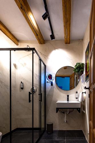 a bathroom with a shower and a sink and a mirror at Casa Joy Sighisoara in Sighişoara