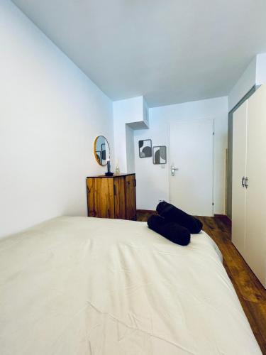 a white bedroom with a large bed and a mirror at Spacious 5BR shared Apartment Near Kaufpark Alterlaa in Vienna