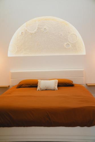 una camera da letto con un grande letto arancione con un cuscino bianco di Cinéma Lune a Montfrin
