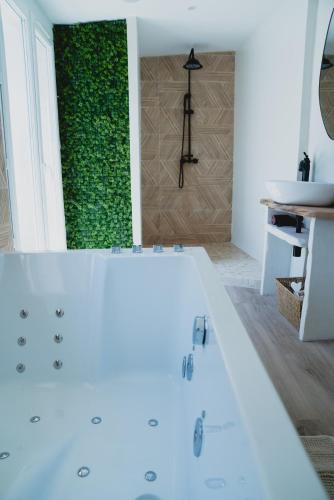un bagno con una vasca bianca e una parete verde di Cinéma Lune a Montfrin
