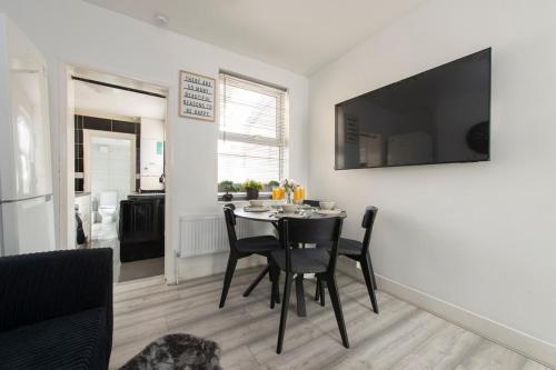 a kitchen and dining room with a table and chairs at Comfort Meets Style, 4-Bedroom Home with All Essentials, Croydon, Sleeps 8! Contractor Friendly! in Thornton Heath