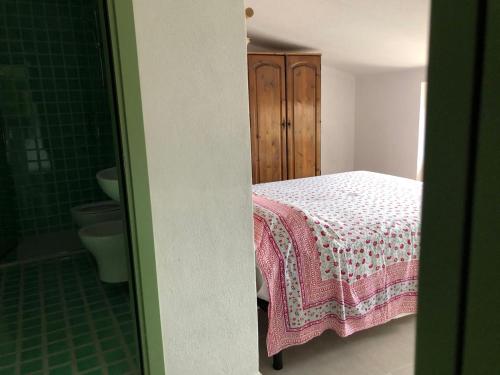 a bedroom with a bed and a bathroom with a shower at La Musica del Vento in Aggius