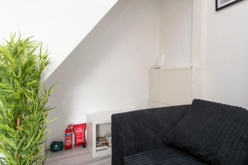 a living room with a couch and a plant at Comfort Meets Style, 4-Bedroom Home with All Essentials, Croydon, Sleeps 8! Contractor Friendly! in Thornton Heath