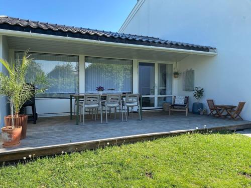a deck with a table and chairs on a house at Large Architect Designed Home in City Centre in Hamar
