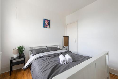 a bedroom with a bed with two white shoes on it at Comfort Meets Style, 4-Bedroom Home with All Essentials, Croydon, Sleeps 8! Contractor Friendly! in Thornton Heath