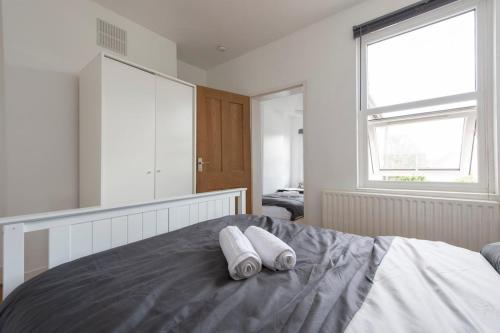 a bedroom with a bed with two towels on it at Comfort Meets Style, 4-Bedroom Home with All Essentials, Croydon, Sleeps 8! Contractor Friendly! in Thornton Heath