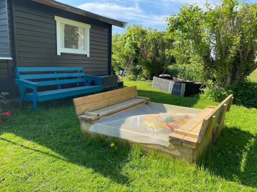 a bench sitting next to a house with a sandbox at Large Architect Designed Home in City Centre in Hamar