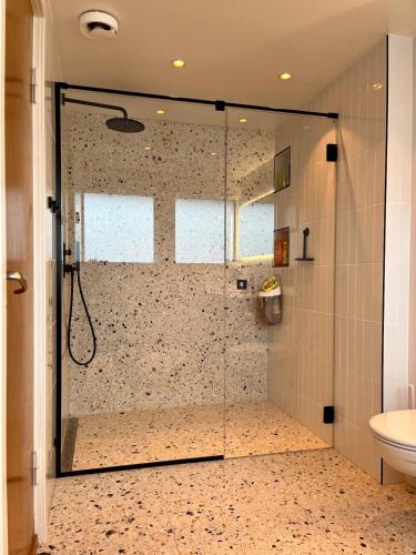 a shower with a glass door in a bathroom at Large Architect Designed Home in City Centre in Hamar
