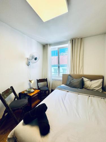 a bedroom with a bed and a chair and a window at Spacious 5BR shared Apartment Near Kaufpark Alterlaa in Vienna