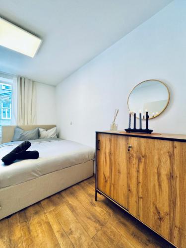 a bedroom with a bed and a mirror on a dresser at Spacious 5BR shared Apartment Near Kaufpark Alterlaa in Vienna