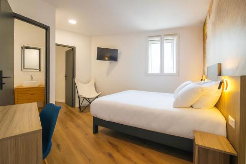 a bedroom with a bed and a desk and a chair at O'Cub Hotel in Villeneuve-lès-Avignon