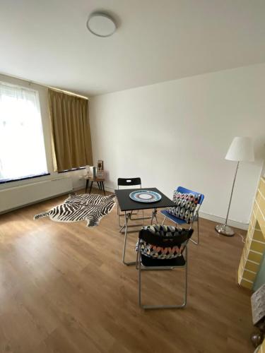 a living room with a table and chairs in it at Stee in Stad in Groningen