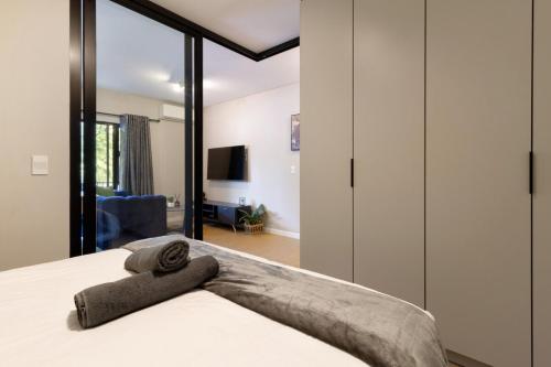 a bedroom with a bed with a towel on it at #AlimamaSpaces The Thando's Akaru in Johannesburg
