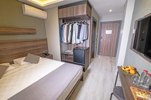 a hotel room with a bed and a closet at Çandarlı Resort Otel in Dikili