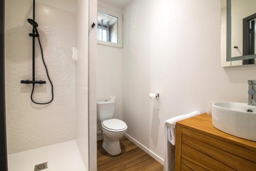 a white bathroom with a toilet and a sink at O'Cub Hotel in Villeneuve-lès-Avignon