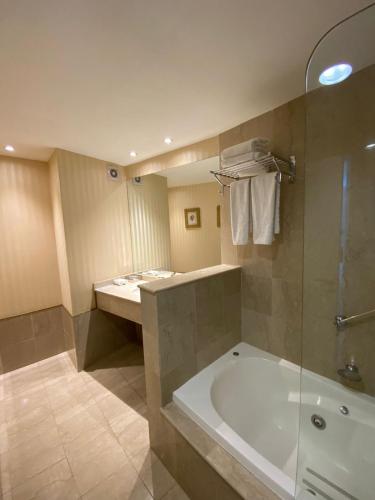 a bathroom with a large tub and a shower at Holiday Inn Rosario by IHG in Rosario
