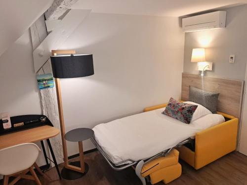 a small room with a bed and a desk at Hôtel des Princes, Chambéry Centre in Chambéry