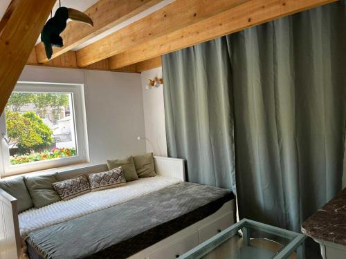 una piccola camera da letto con un letto e una finestra di Villa septembre logement VANILLE a Lamalou-les-Bains