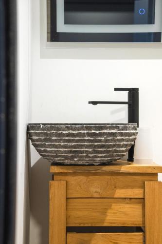 a bathroom with a stone sink on a wooden table at O'Cub Hotel in Villeneuve-lès-Avignon